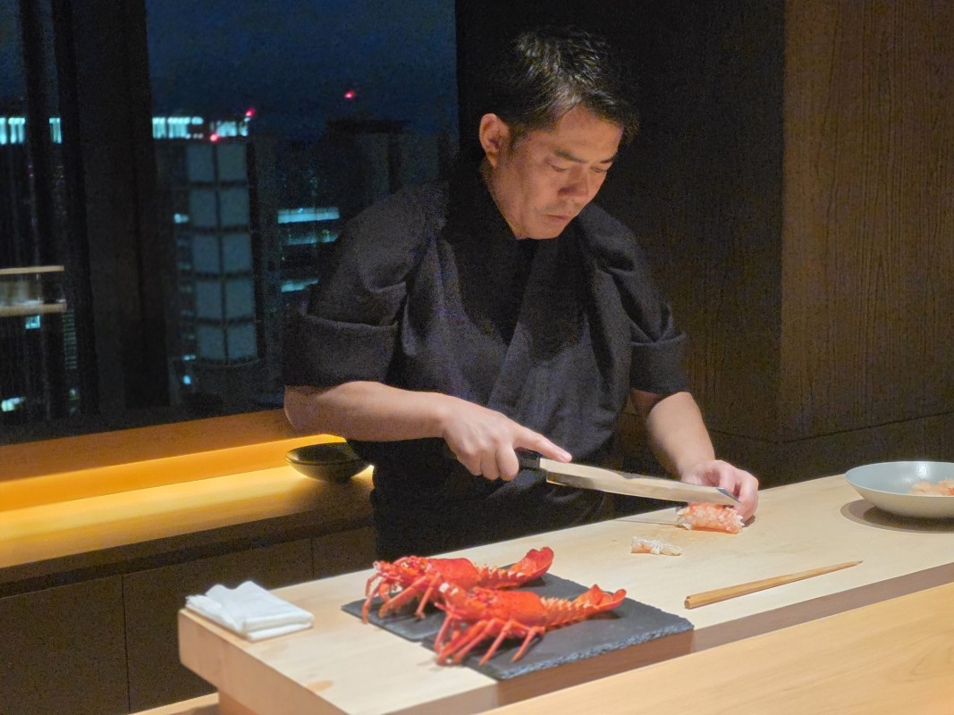 カウンターで料理を仕上げる中川料理長